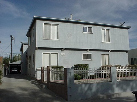 a white house with a fence and a driveway