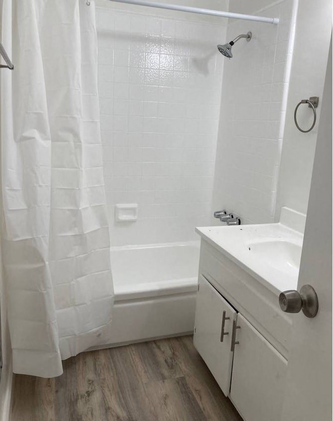 a white bathroom with a shower and a sink