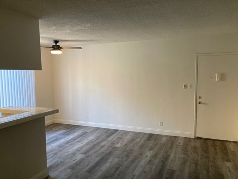 A room with a ceiling fan and a door.