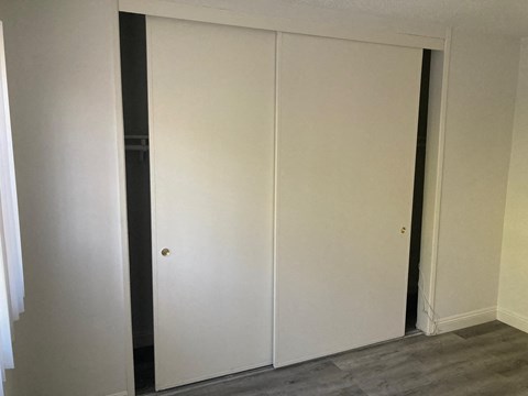 A white door is closed in a room with grey flooring.