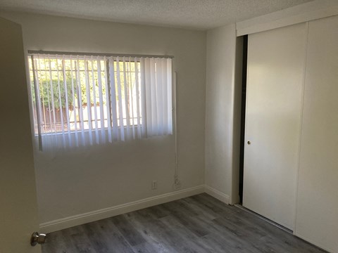 A room with a sliding door and a window with blinds.