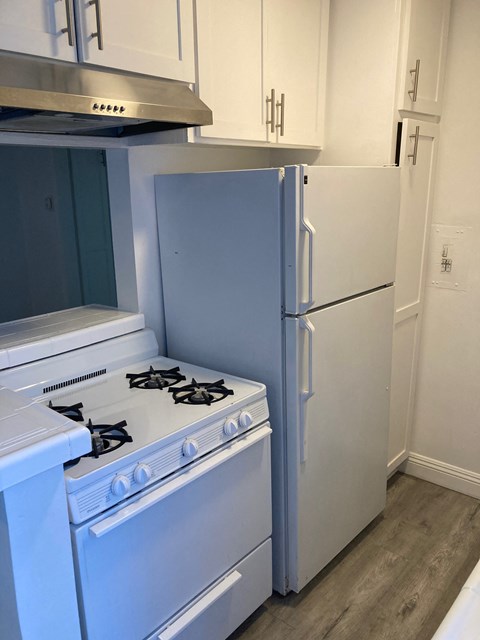 A white stove and refrigerator in a kitchen.