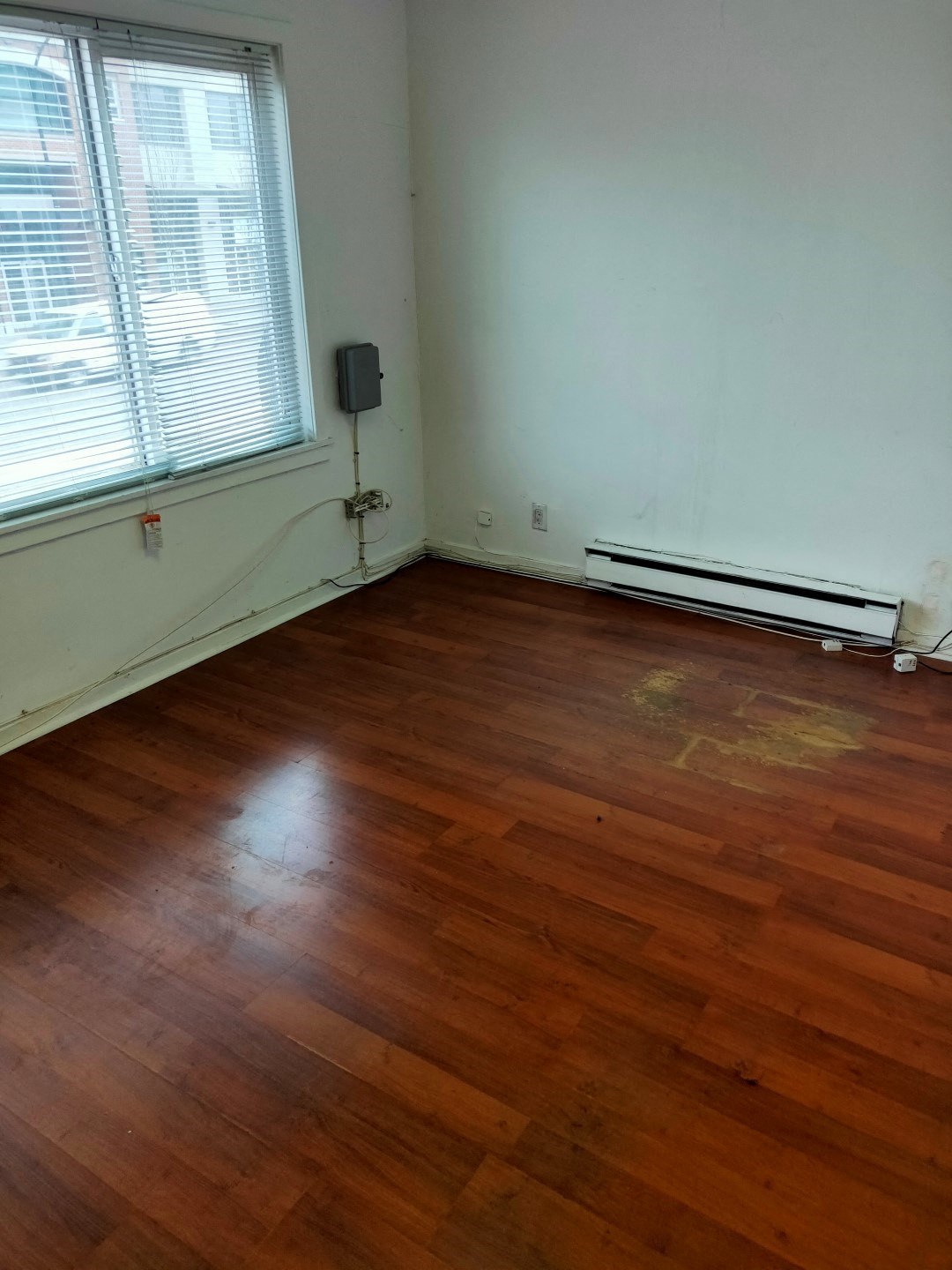 A room with a wooden floor and a window.