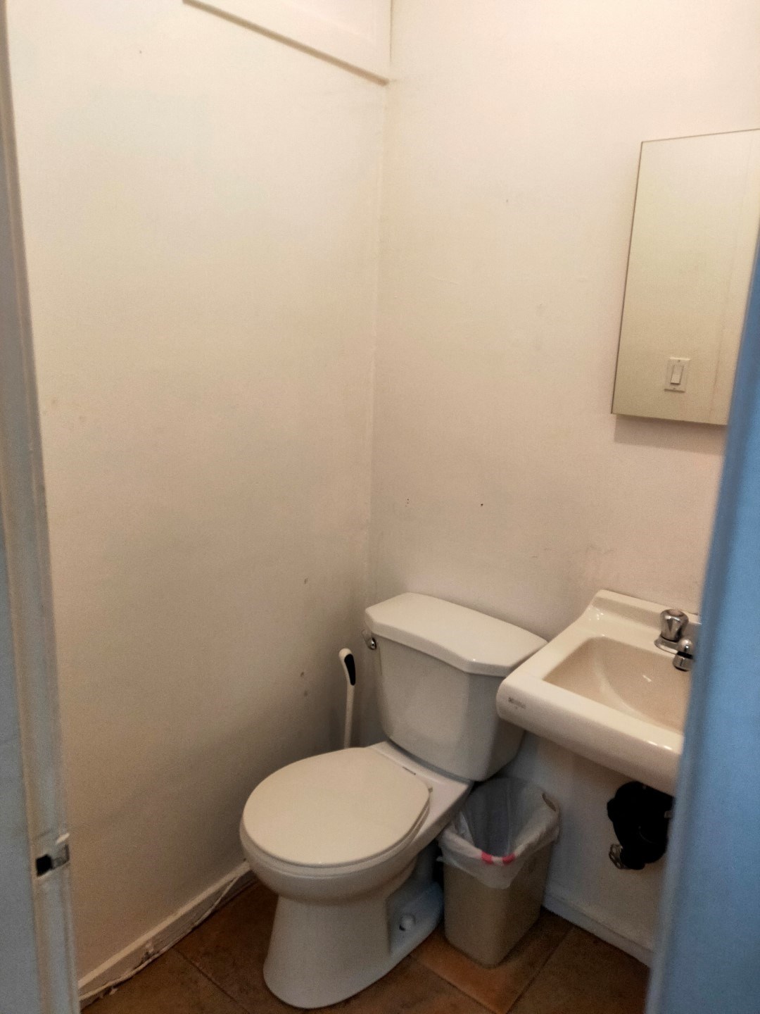 A white toilet and sink in a small bathroom.