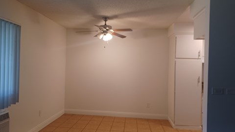 an empty living room with a ceiling fan