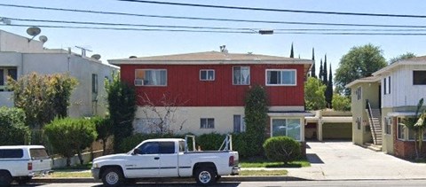 a white truck parked in front of a red house