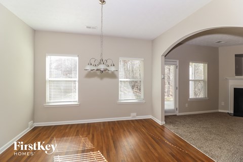 a living room with wood floors and a fireplace and a chandelier