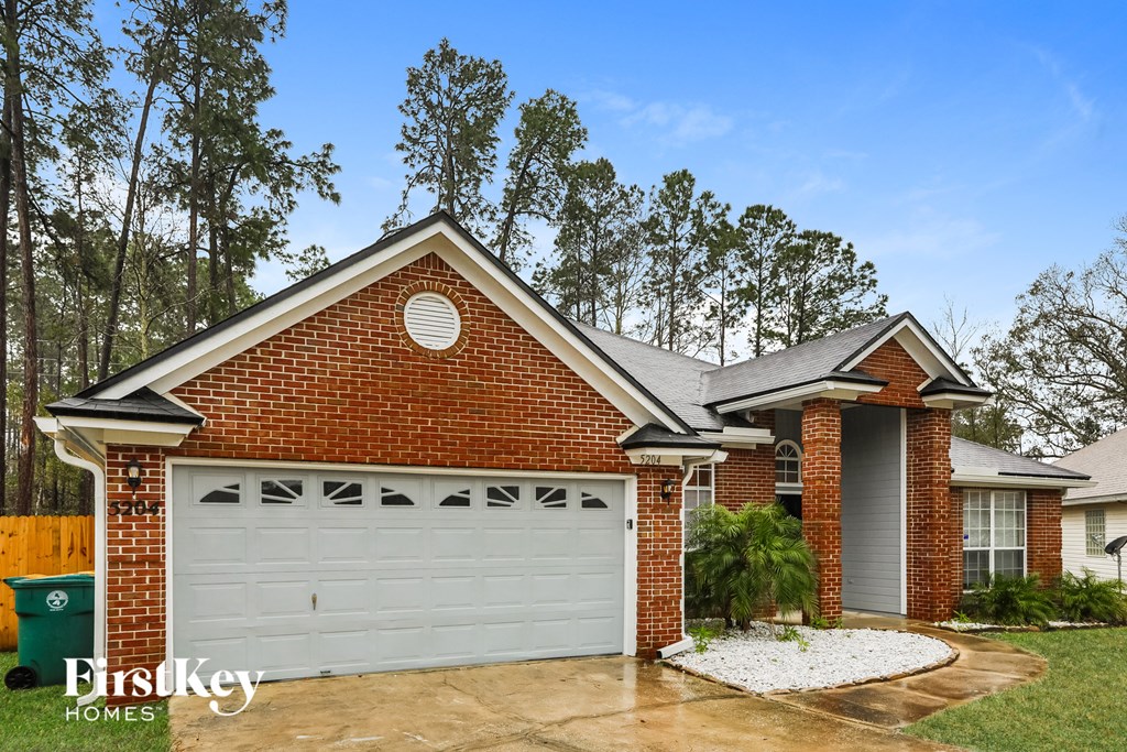 a home with a white garage door and a brick house