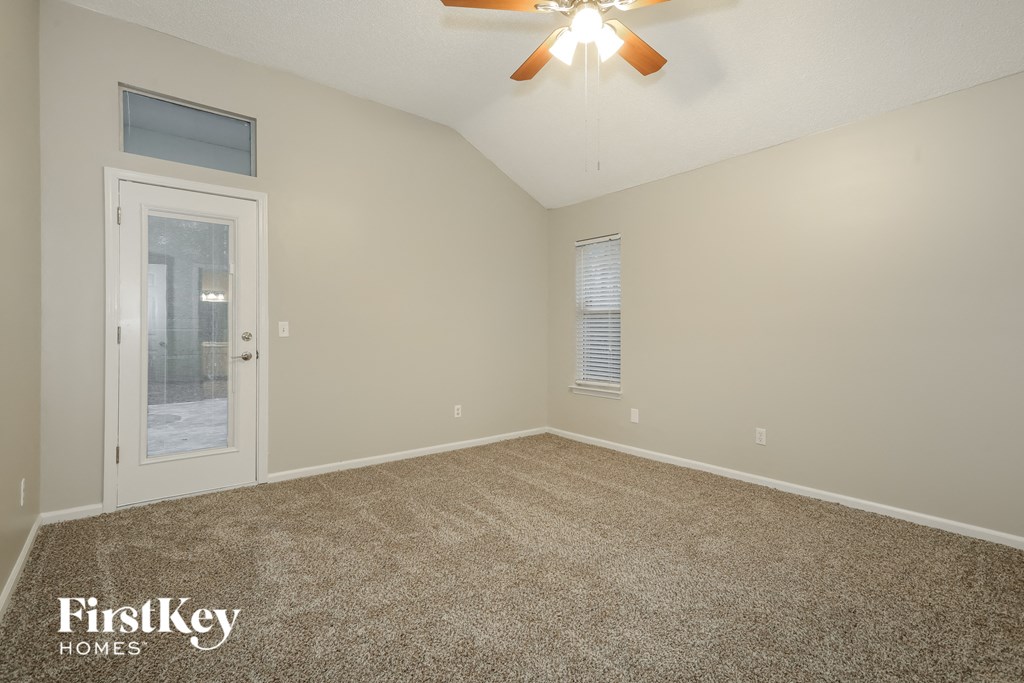 the master bedroom has a door to the porch and carpeted flooring