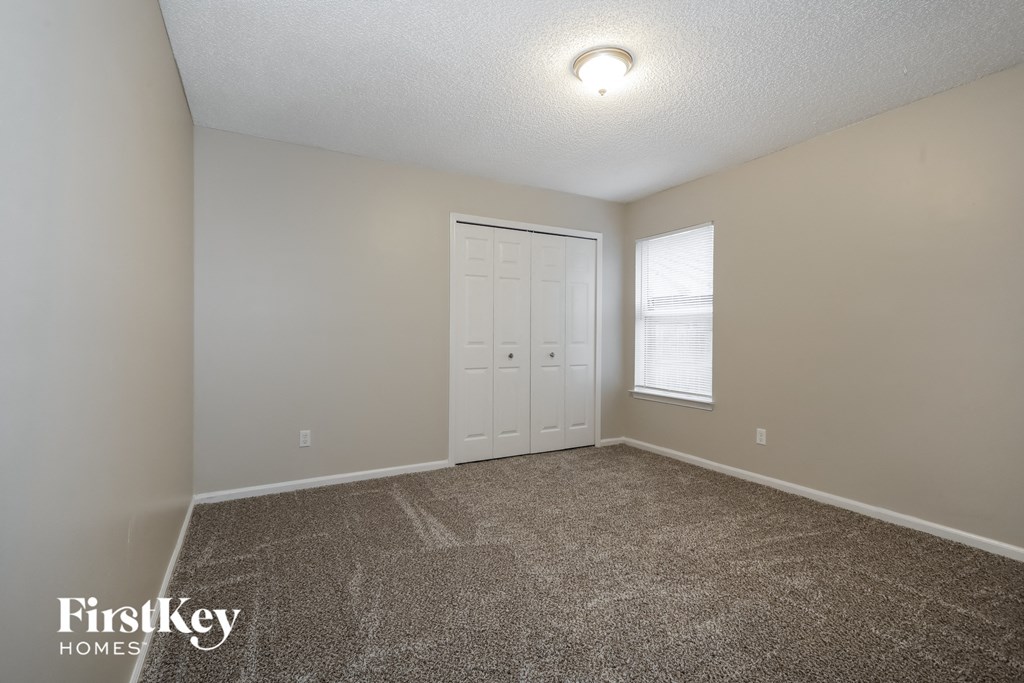 the spacious living room with white doors and carpeted flooring