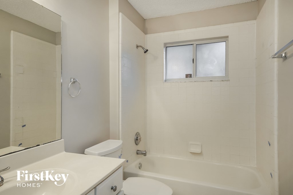 a white bathroom with a tub and a toilet and a sink