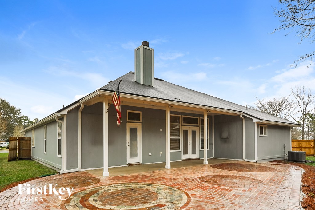 the front of a house with an flag and a brick patio