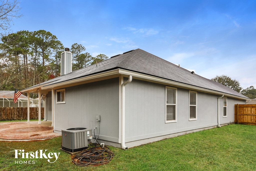a white house with a grey roof and a backyard