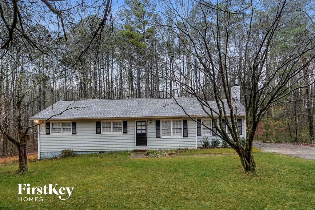 a small white house in the middle of the woods