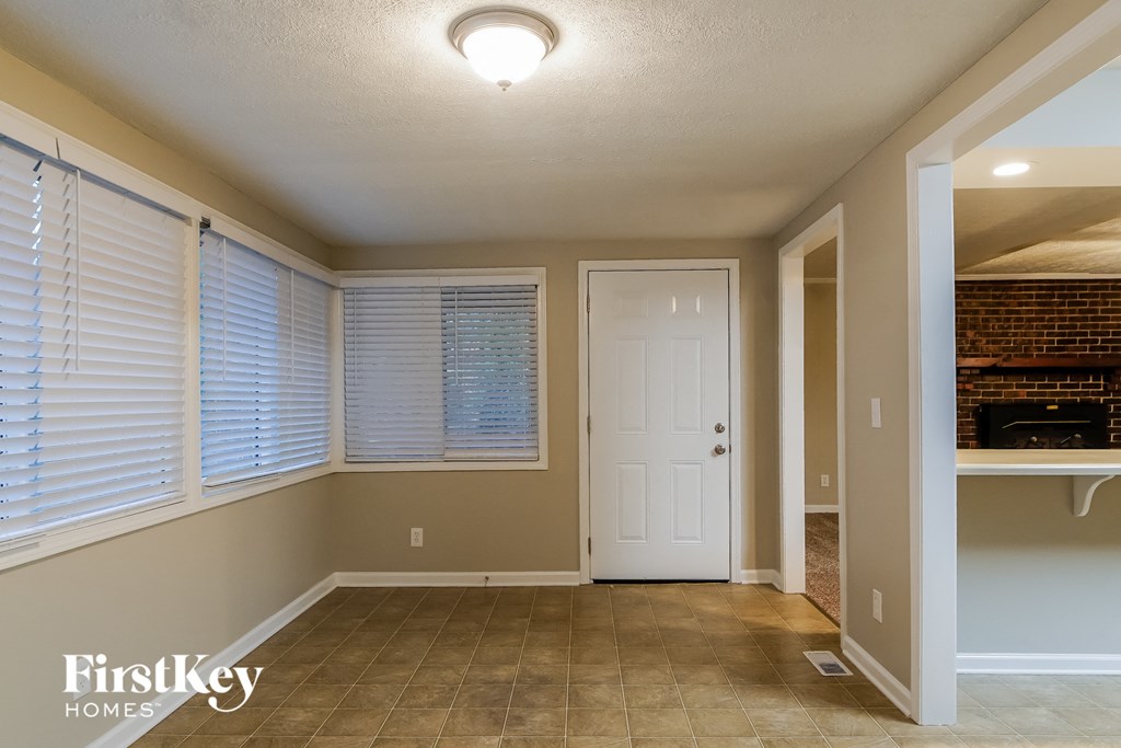 a dining room with a large window and a white door