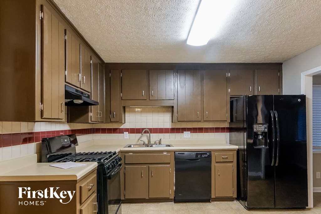 a kitchen with black appliances and wooden cabinets
