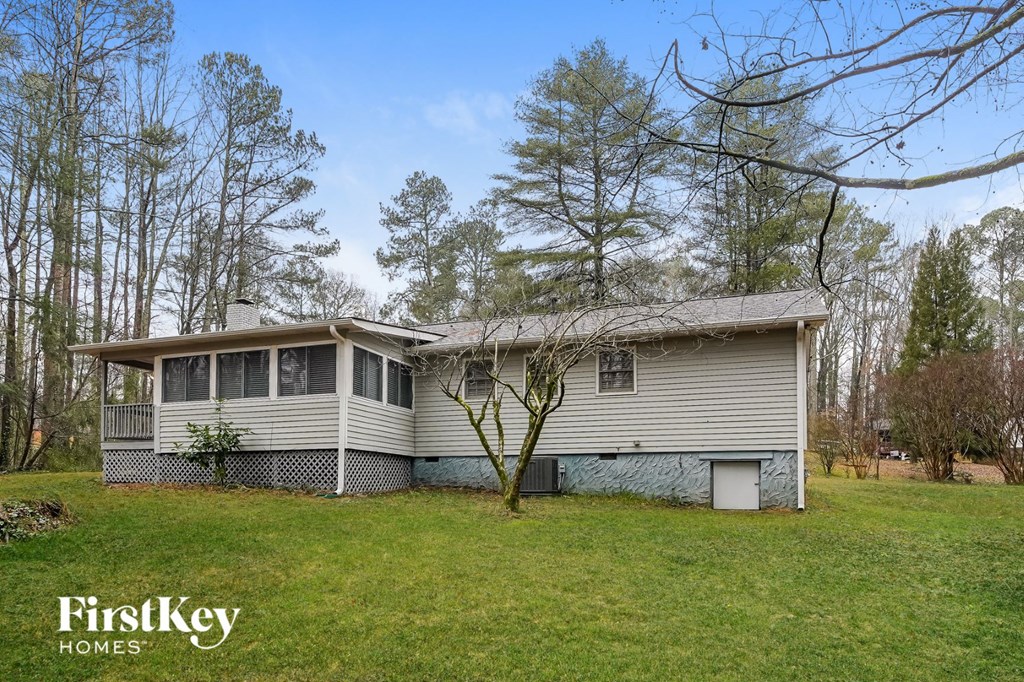 a white and gray house on a green lawn with trees