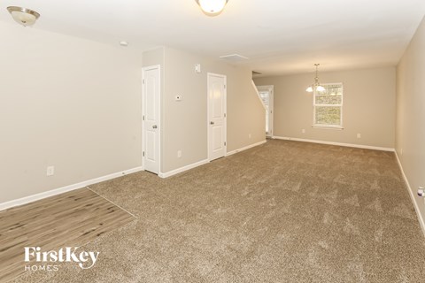 A spacious room with a carpeted floor and a light fixture on the ceiling.