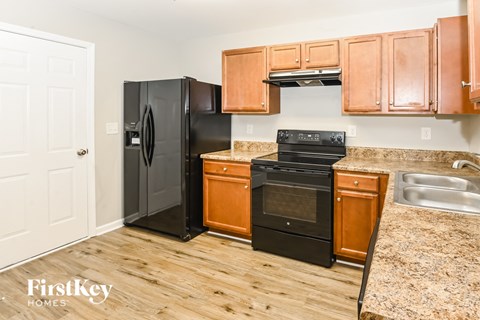 A kitchen with wooden cabinets and black appliances.