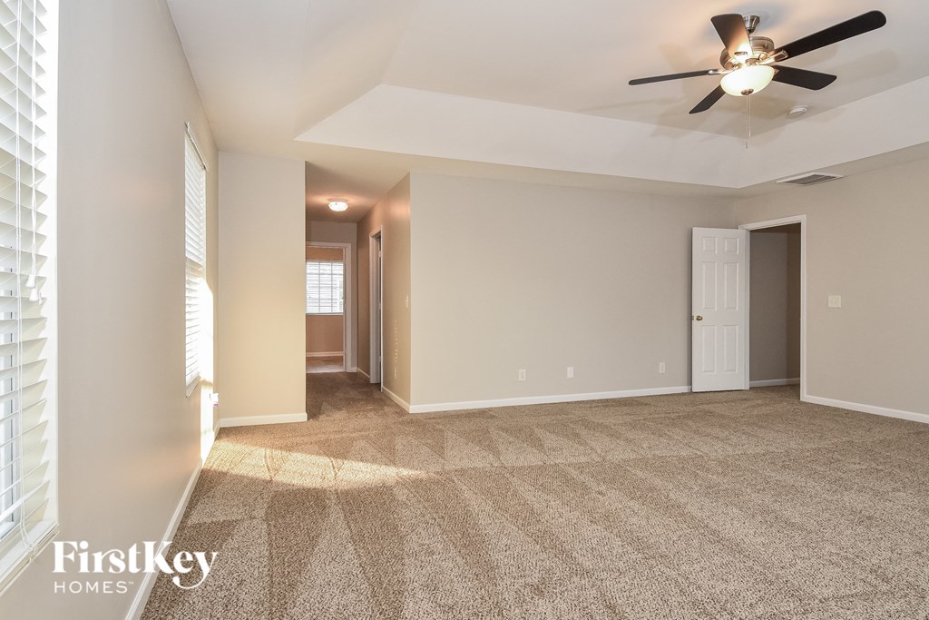 the living room of an empty house with a ceiling fan