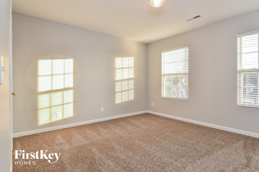 the living room of a new home with carpet and windows