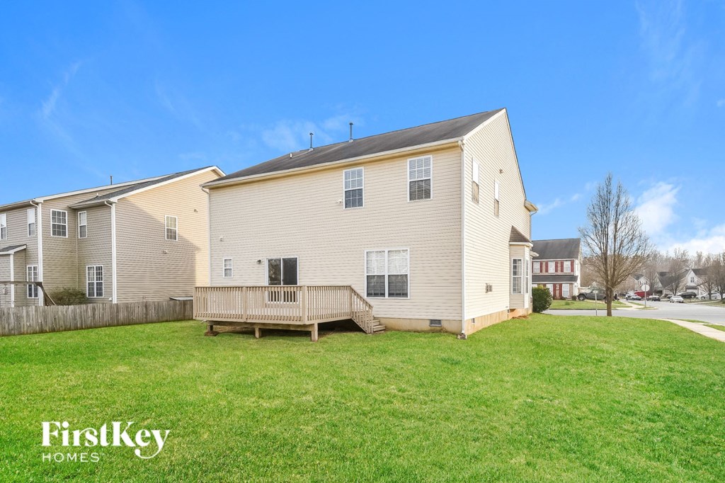 a yellow house with a porch and a green lawn