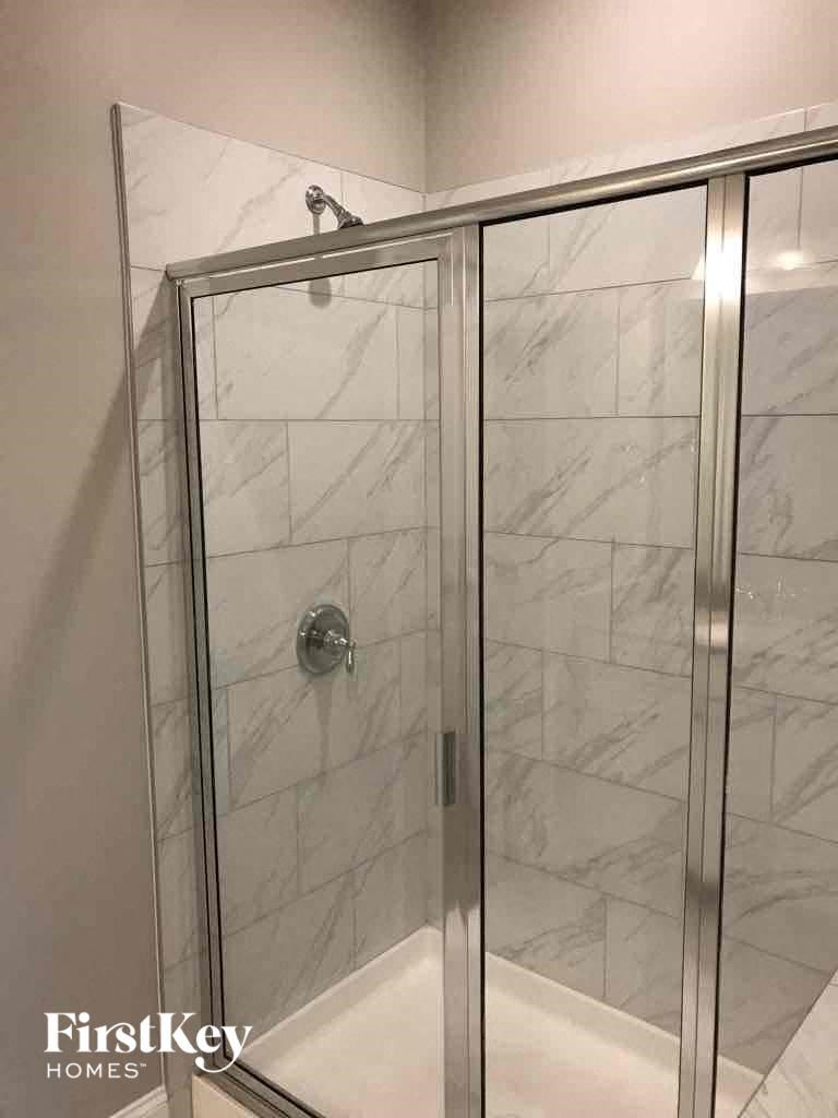 a walk in shower in a bathroom with a glass door
