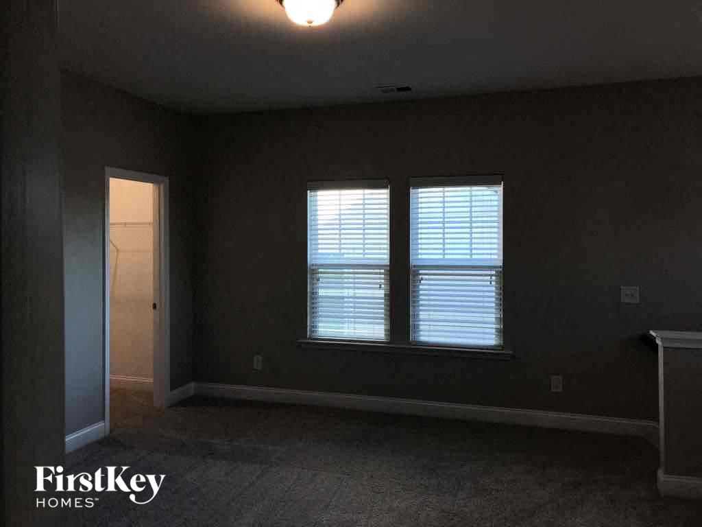 a dark room with two windows and a door