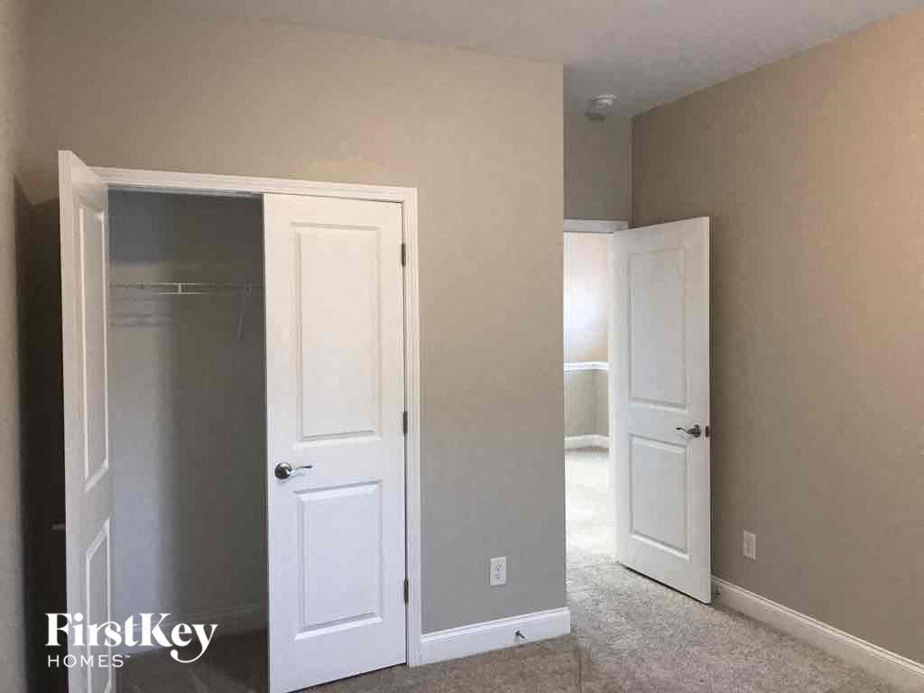 an empty bedroom with two white doors and a closet