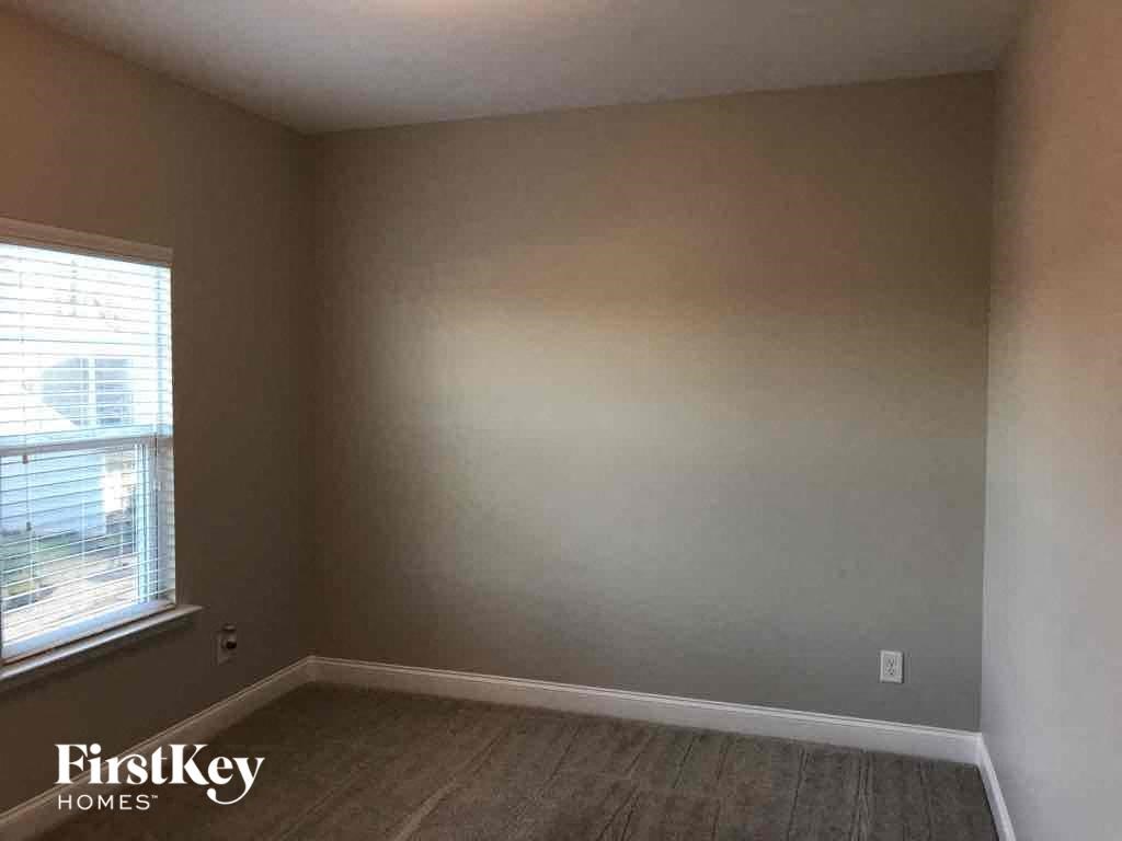an empty room with a window and a wooden floor