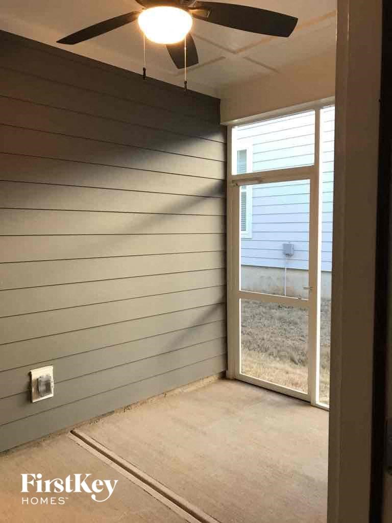 a room with a sliding glass door and a ceiling fan