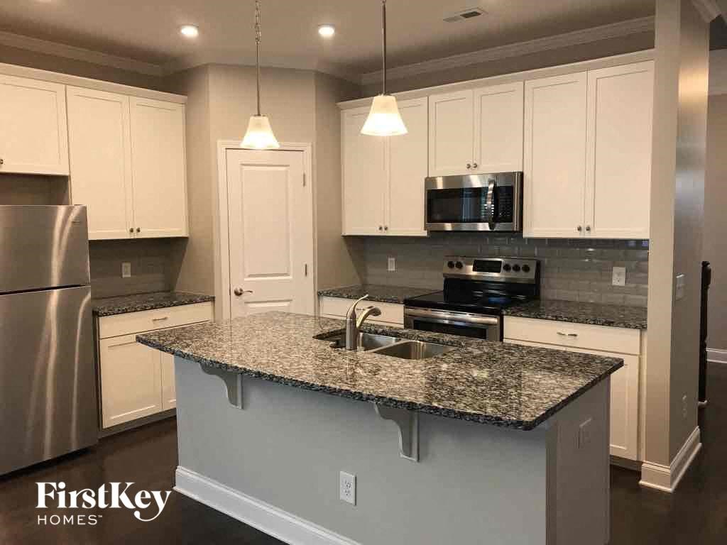 a kitchen with white cabinets and a granite counter top