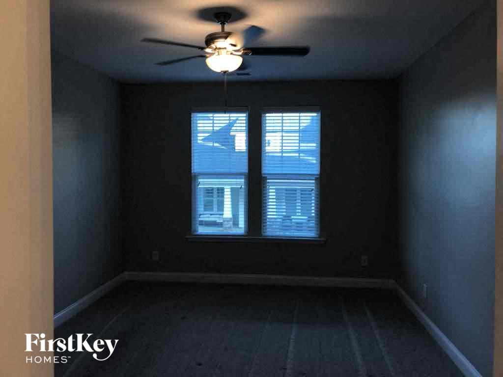 a empty room with a ceiling fan and a window