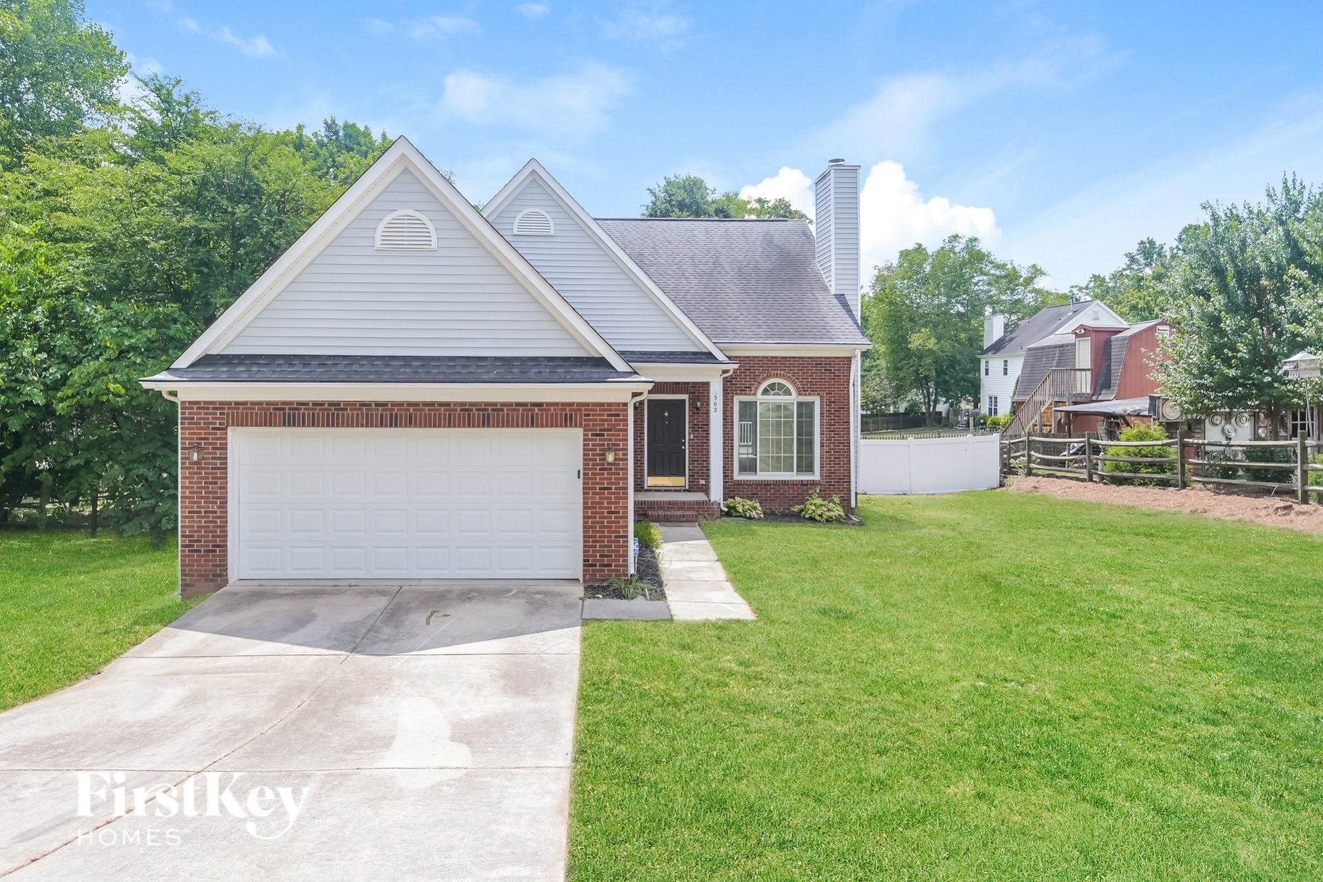 a brick house with a white garage door and a lawn