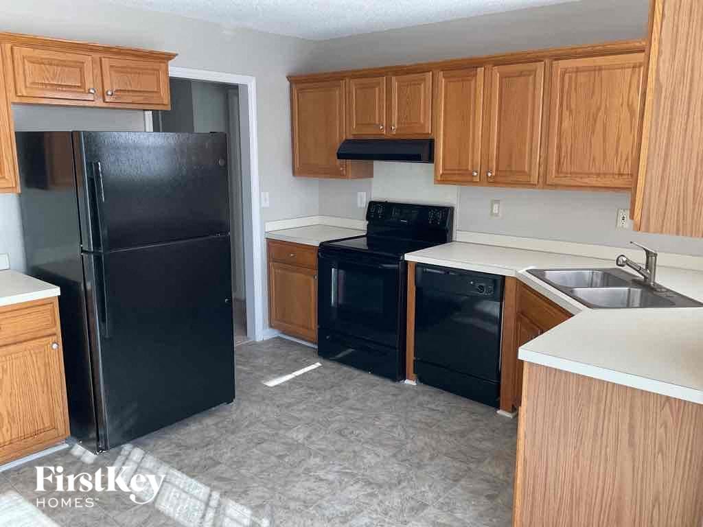 a kitchen with black appliances and wooden cabinets