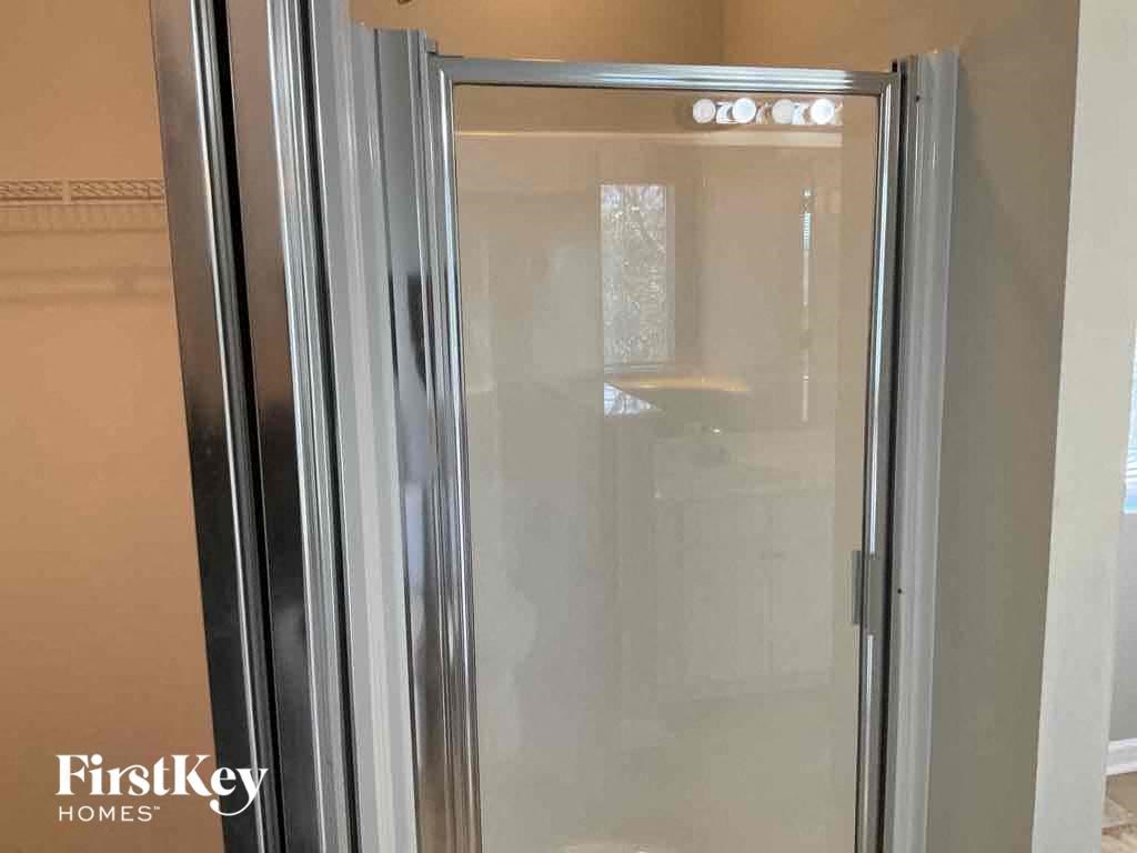 a bathroom with a shower with a glass door