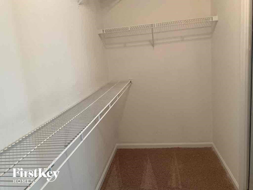 a walk in closet in a small room with a shelf