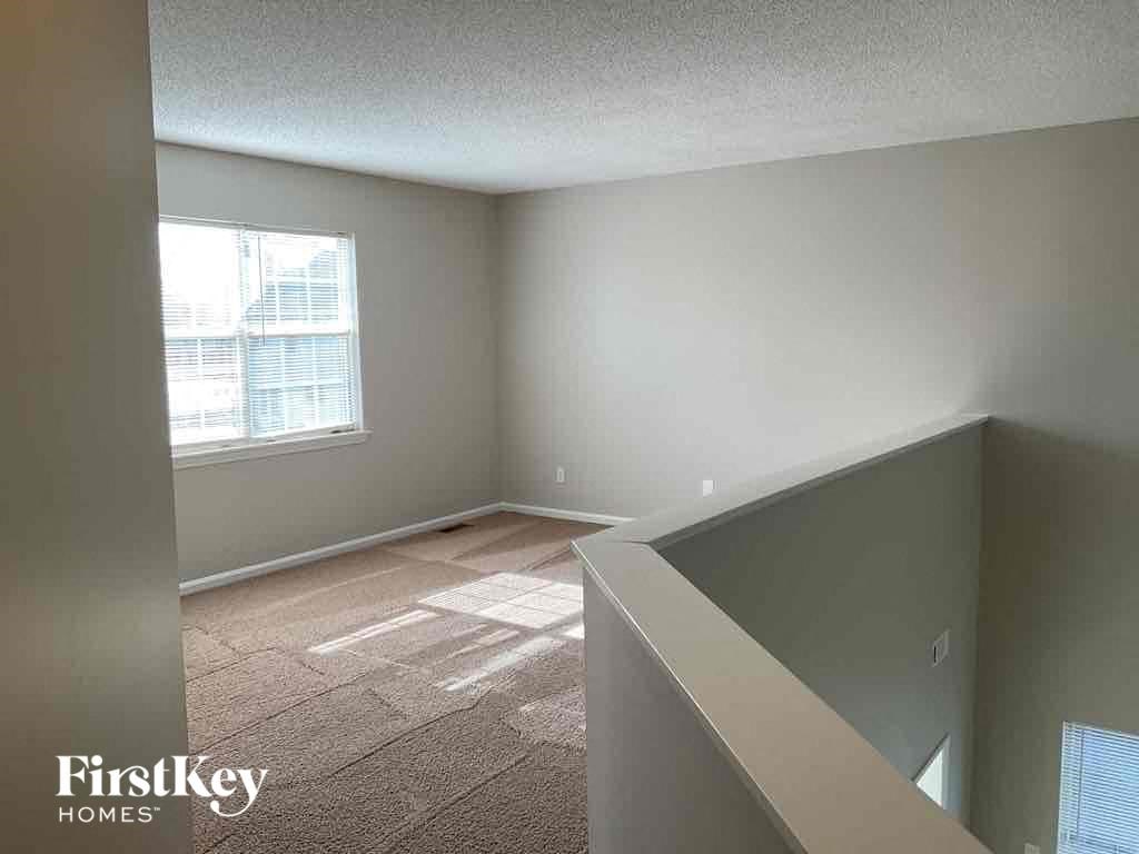 an empty living room with a window and a staircase