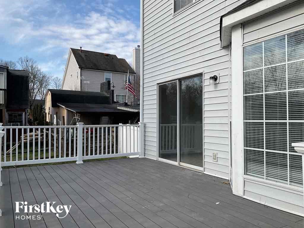 a patio with a white house and a white fence
