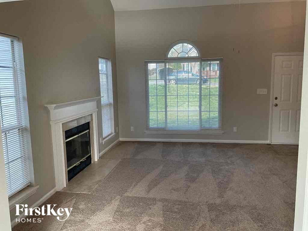 an empty living room with a fireplace and a large window