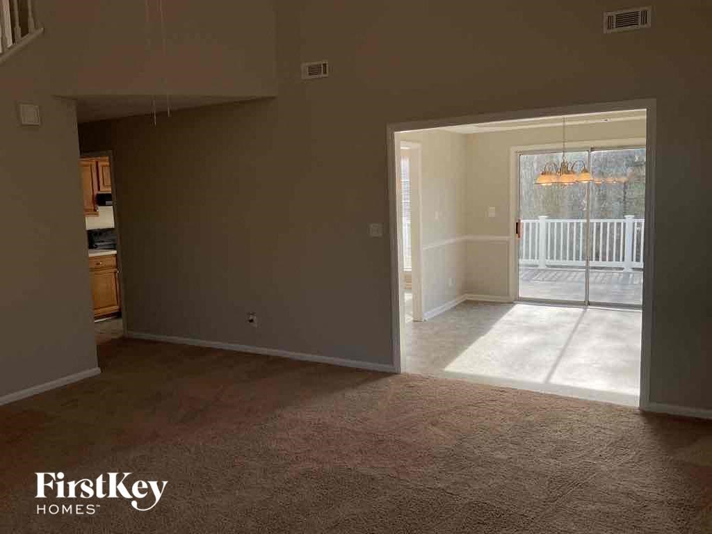 an empty living room with a sliding glass door to a patio