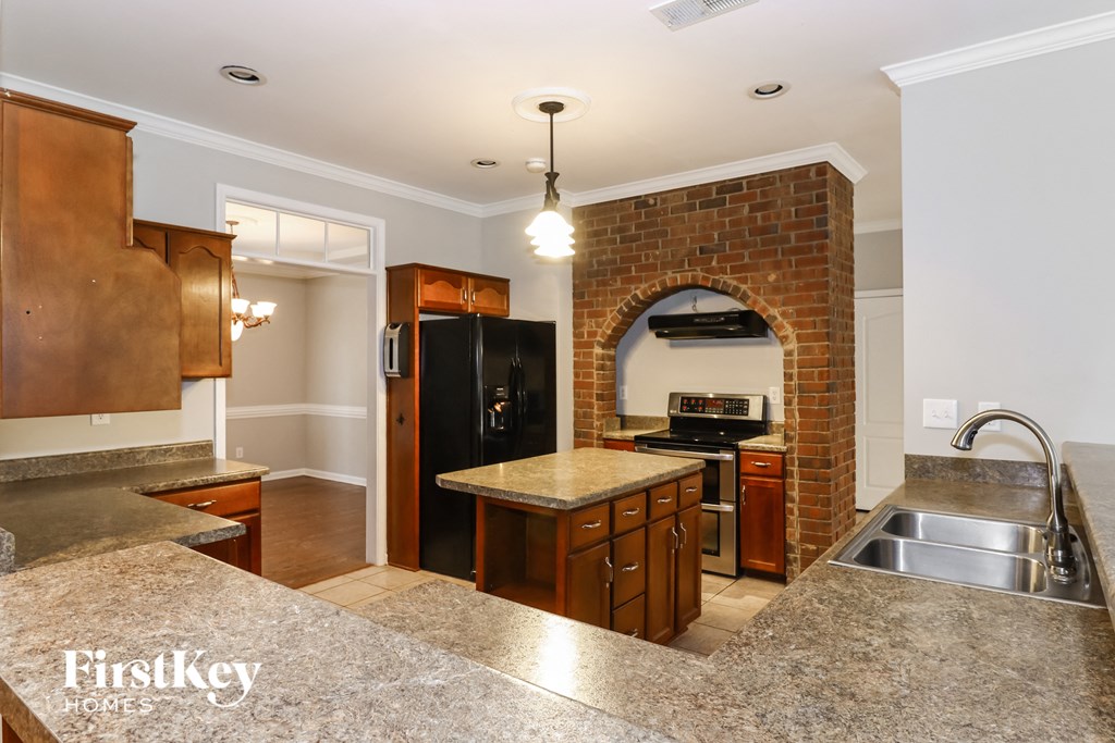 a kitchen with a brick archway and a large sink