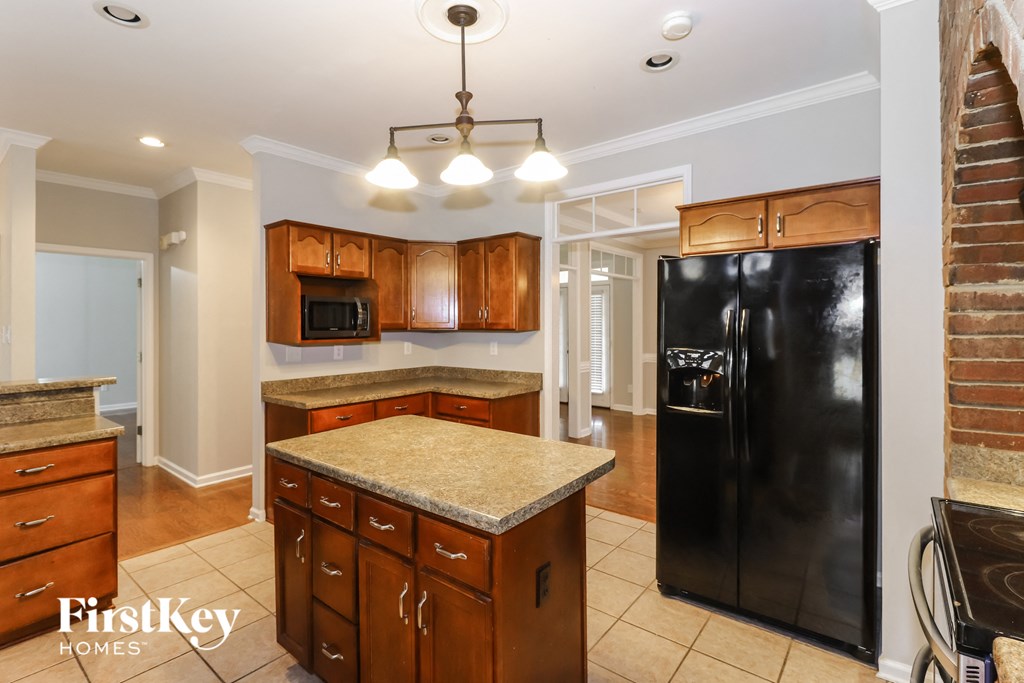 a kitchen with a black refrigerator and a counter top