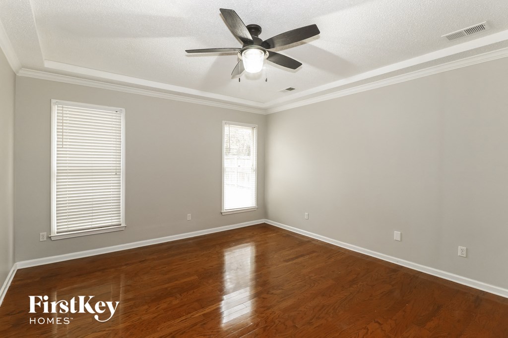 a bedroom with a ceiling fan and wood floors