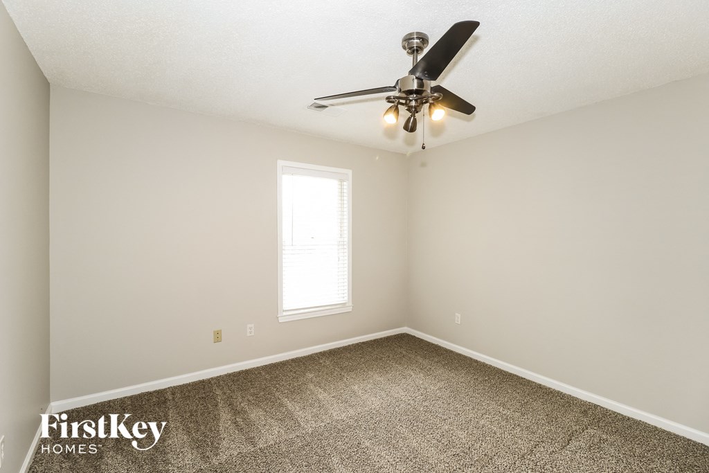 a bedroom with carpet and a ceiling fan
