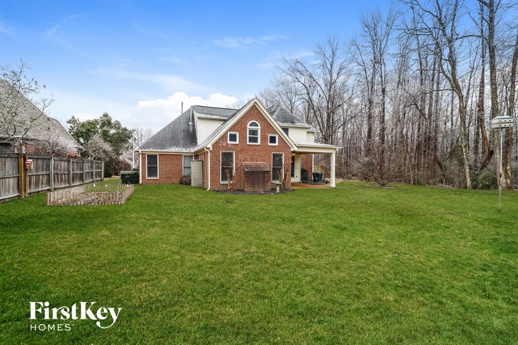 a brick house with a yard and a fence