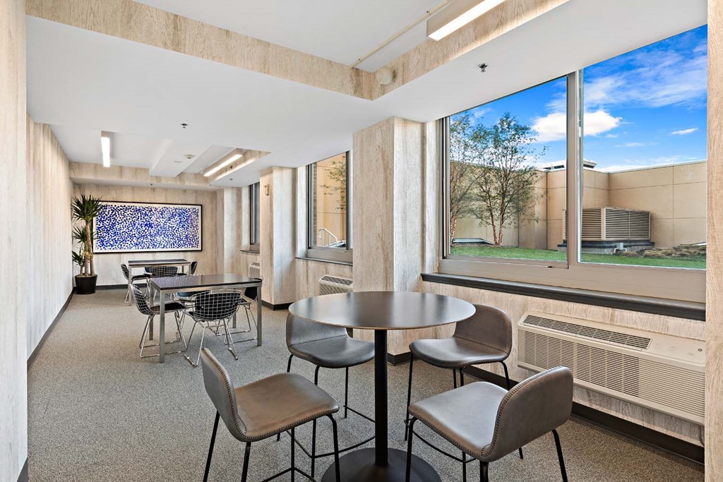 a room with tables and chairs and a large window