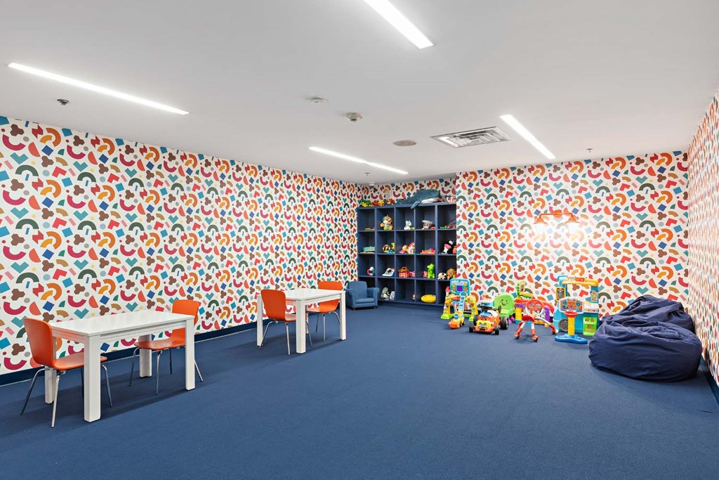 a room with tables and chairs and toys and wallpaper