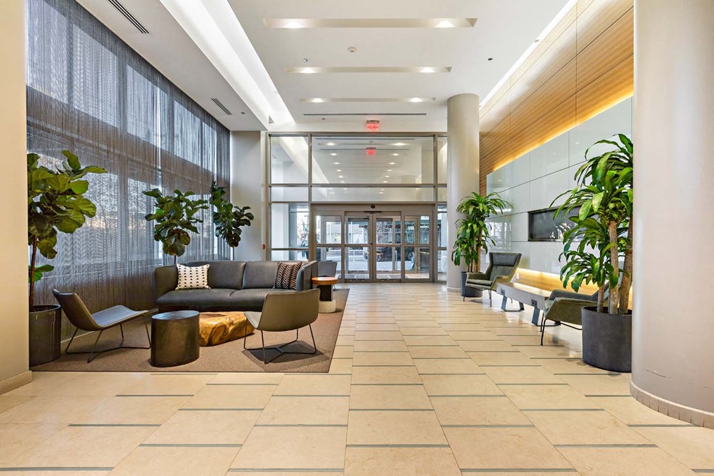 a large lobby with couches and chairs and plants