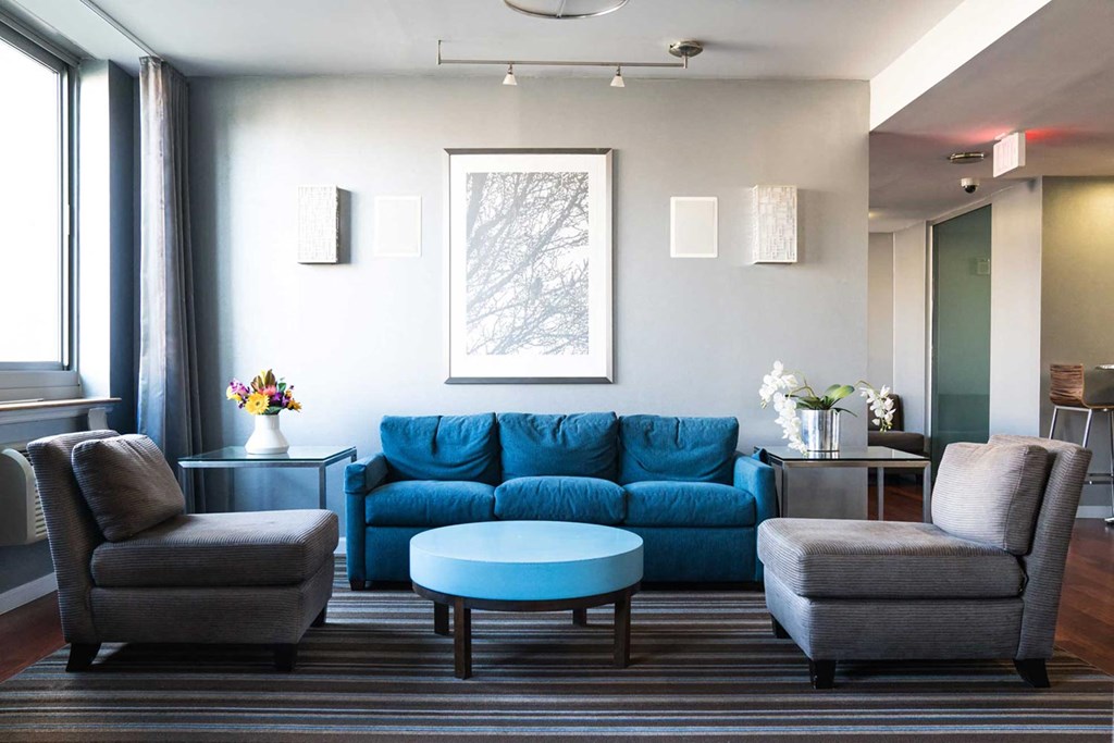 a living room with a blue couch and two chairs